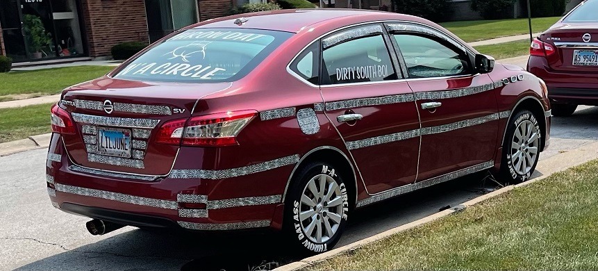 Throw Dat A** N'A Circle? Lil June Tacky Nissan Sentra With Camo Strips and 'Throw Dat A** N-A Circle' Slogan Goes Viral. Lil June license plate camo strip Nissan Sentra with 'Throw Dat A** N-A Circle' Slogan on tires.