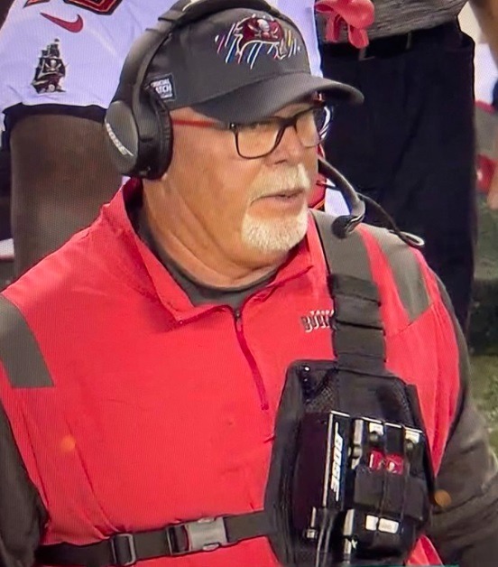 Bruce Arians' Suicide Bomber Outfit on Sideline of Buccaneers vs Eagles Goes Viral. People showing Bruce Arians wearing a suicide bomber vest outfit during Bucs vs Eagles. Bruce Arians' Darth Vader outfit. Bruce Arians' outfit compared to Darth Vader