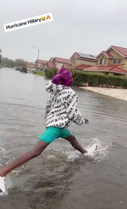 Black Woman Doing a Split in the Hurricane Hilary Flood Water while celebrating