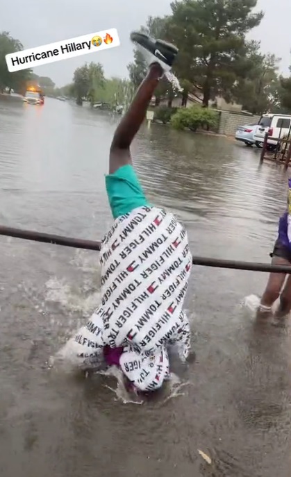 Black people celebrating Hurricane Hilary with a game where people have to jump over a pole being held by two other people